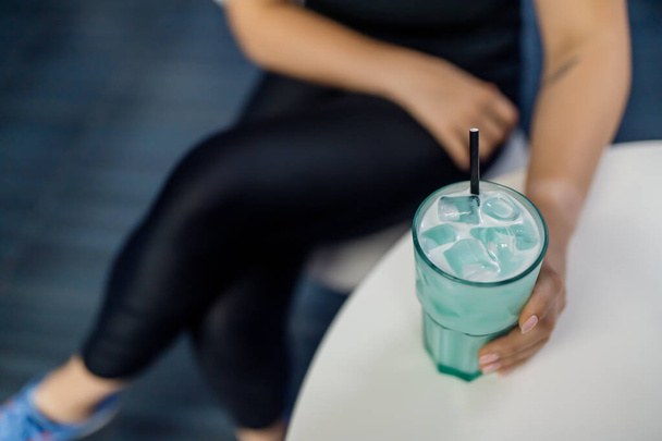 Fitness fille tenant un verre avec boisson nutritive sportive - Photo, image