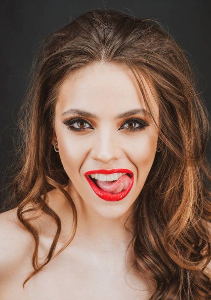 Sensual woman open mouth, tongue touches the teeth. Close-up licking sexy red lips. - 写真・画像