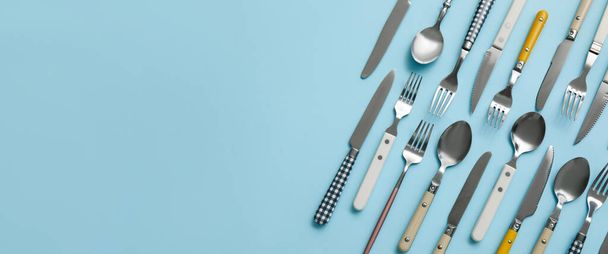 Many different cutlery on blue background with space for text - Foto, imagen