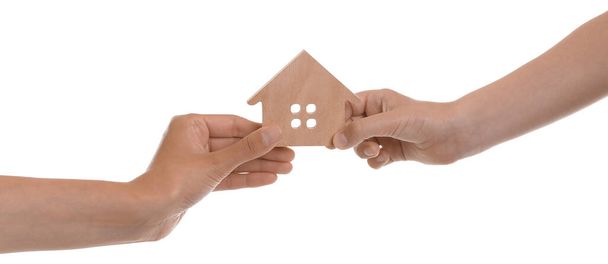 Hands of parent and child with small figure of house on white background - Photo, image