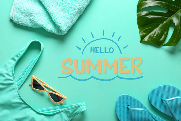 Set of female beach accessories and text HELLO SUMMER on blue background - Fotó, kép
