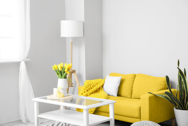 Interior of modern living room with yellow sofa and Easter decor - Fotó, kép