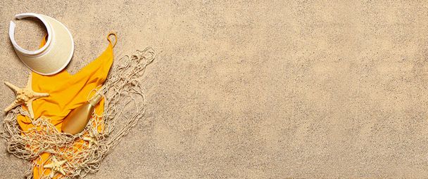 Σύνολο από κομψά γυναικεία αξεσουάρ με δίχτυ στην άμμο με χώρο για κείμενο - Φωτογραφία, εικόνα