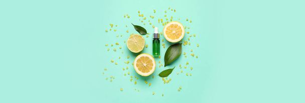 Bottle of natural serum, green leaves, lemon, lime and sea salt on turquoise background. Banner for design - Photo, image