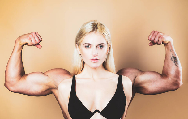 Female model keeps fit and healthy, raises hands and shows muscles, power. Strong muscle arms. Funny sport, woman with man muscle arms on back. Young girl showing bicep on her arm. - Valokuva, kuva