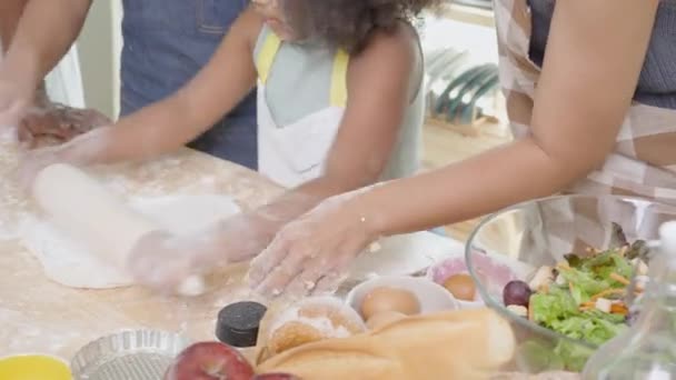 Close-up Afro-Amerikaanse familie met dochter rollen voor verse bloem voor het koken met vader en moeder samen in de keuken thuis, ouder en weinig kind activiteit het bereiden van voedsel met plezier. - Video