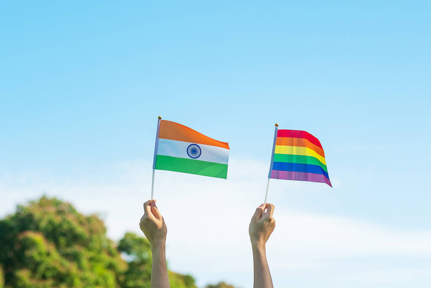 hands showing LGBTQ Rainbow and India flag on nature background. Support Lesbian, Gay, Bisexual, Transgender and Queer community and Pride month concept - Photo, Image