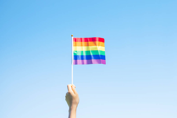 руки, показывающие флаг ЛГБТК Радуга на фоне природы. Support Lesbian, Gay, Bisexual, Transgender and Queer community and Pride month concept - Фото, изображение