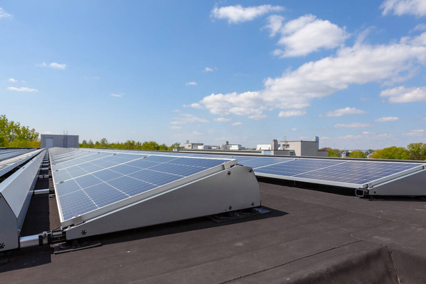 em um edifício em uma área residencial, há painéis solares no telhado no dia ensolarado - Foto, Imagem