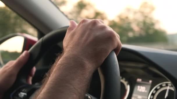 Driver holds steering wheel of car driving in highland - Materiał filmowy, wideo