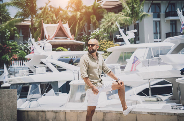 Portrait of a fashion young man posing at marina and yahts background - Φωτογραφία, εικόνα