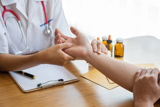 Изображение медсестры, проверяющей пульс пациента. Женщина-врач пожимает руку, давая пациенту мужскую уверенность и консультацию. - Фото, изображение