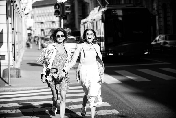 Two excited happy women walking running together on the street. Funny vacation, romantic travel. - Photo, Image