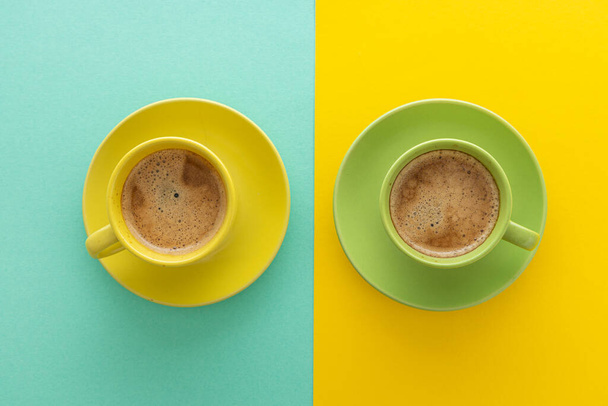 Dos tazas de café sobre fondo azul y amarillo. Vista superior. Minimalismo concepto de café. - Foto, Imagen