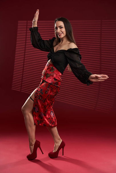 Full body of a beautiful glamour model in red skirt and black blouse - Fotó, kép
