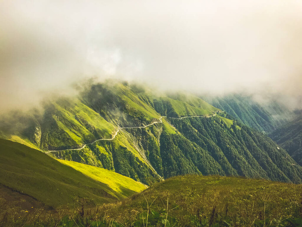 Cinematic stunning Tusheti road panorama with mist and green landscape. Georgian extreme tours adventure travel - Fotó, kép