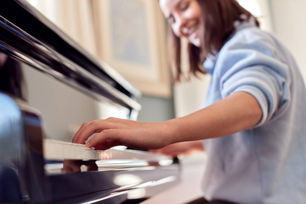 Close Up Of Smiling Teenage Girl At Home Playing The Piano - Foto, immagini