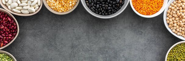 Banner of various types of legumes in bowls, green and yellow peas, chickpeas and peanuts, colored beans and lentils, mung beans and beans, top view, copy space - Valokuva, kuva