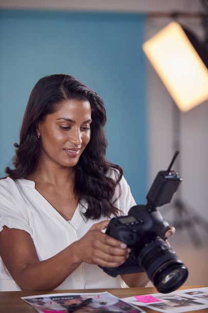 Mature Female Photographer Checking Images On Camera During Fashion Shoot In Studio - Φωτογραφία, εικόνα