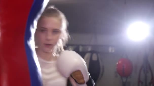 Женщина-боксер тренирует удары, тренировочный день в боксерском зале, женщина быстро бьет серию  - Кадры, видео