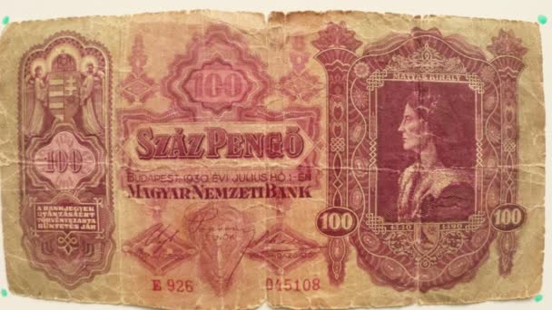 Papel moneda 100 Pengo Magyar Budapest en 1930 sobre una mesa blanca volteó una mano de cerca retrato Matías Kirali
 - Imágenes, Vídeo