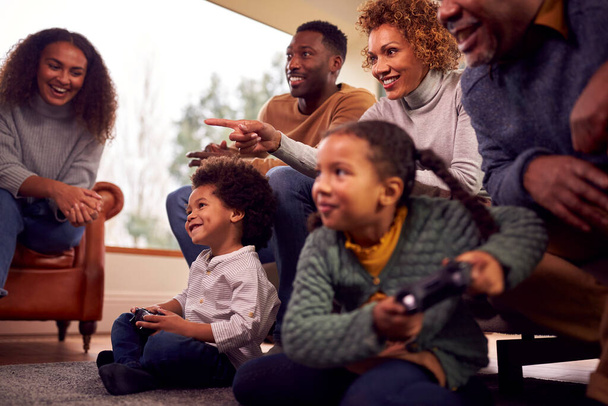 Multi-Generation Family Having Fun Playing Video Game In Lounge At Home Together - Foto, immagini