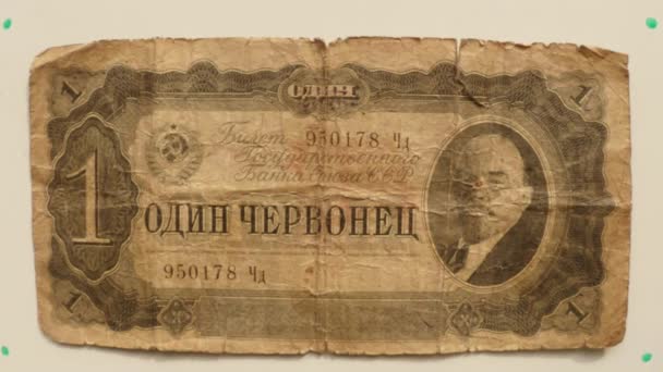 Papiergeld 1 tsjervonets ticket staatsbank van de Ussr in 1937 op een witte tafel gespiegeld een hand dicht omhoog, portret Lenin - Video