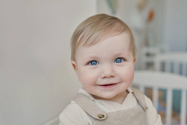 Wonderful baby boy with blue eyes. Child playing with toys in nursery. Early development, kindergarten, nursery, playroom. Children's Day, Mother's Day. - 写真・画像