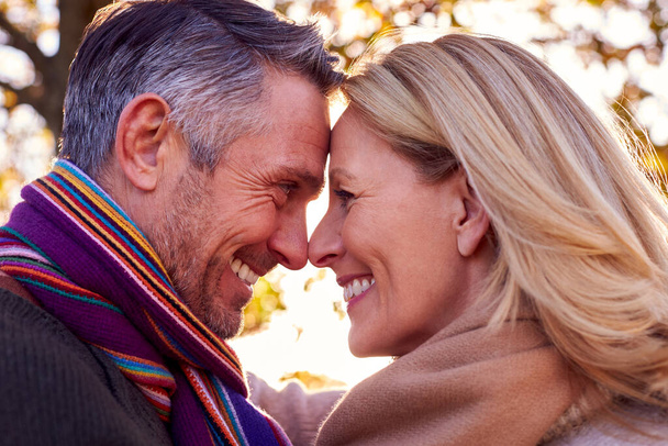 Loving Mature Retired Couple Hugging Against Autumn Countryside With Flaring Sun - Foto, Imagem