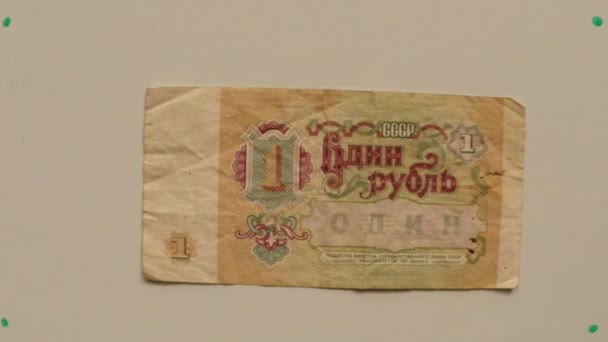 Pieniądz papierowy 1 Rubel ZSRR w 1991 na stół biały uniesiona ręka bliska - Materiał filmowy, wideo