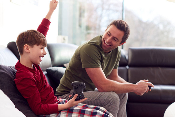 Boy In Pyjamas Wearing Virtual Reality Headset Playing Computer Game At Home - Foto, imagen
