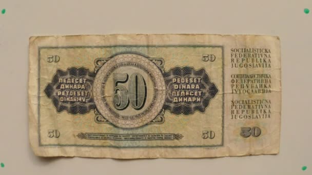 Паперові гроші 50 динарів Югославії в 1976 році на білий таблиці перевернуто руку крупним планом - Кадри, відео