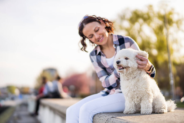 Adult woman is enjoying sunny day with her dog. - Foto, Bild