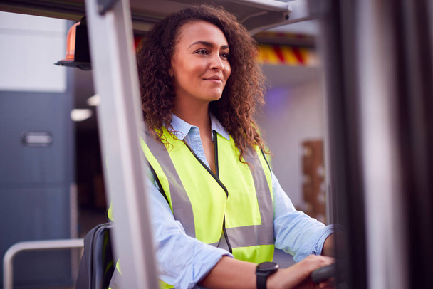 Female Worker Operating Fork Lift Truck At Freight Haulage Business - Foto, afbeelding
