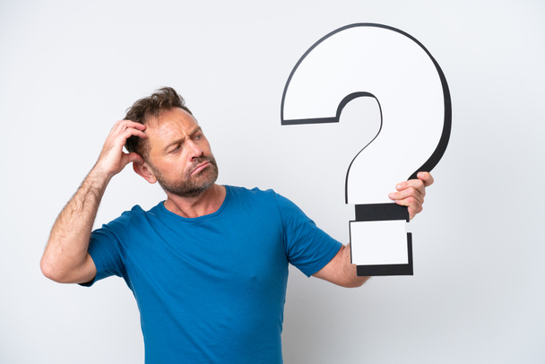 Middle age caucasian man isolated on white background holding a question mark icon and having doubts - 写真・画像