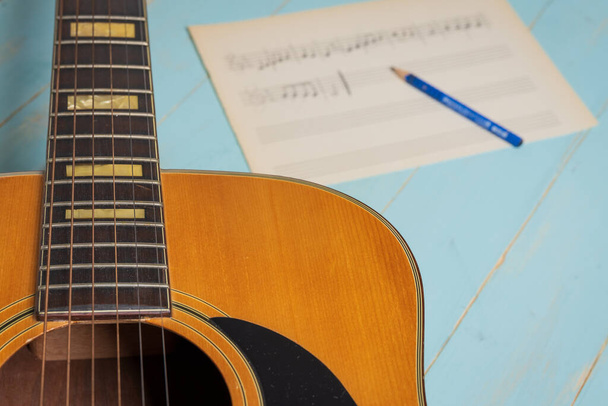 Music recording scene with guitar, music sheet and pencil on wooden table - Foto, immagini