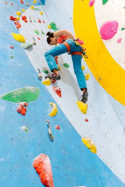 Young Woman rock climbing indoors. - Foto, Imagen