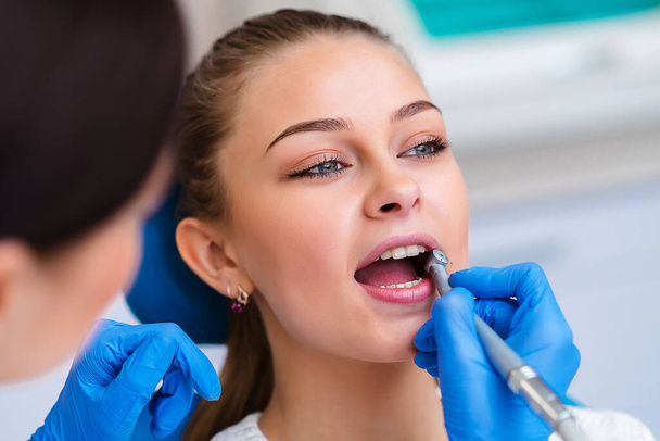 Orvos vizsgálja a beteg fogait, közelről. Kozmetikai fogászat - Fotó, kép