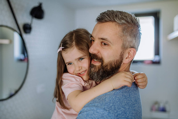 Happy father hugging his little daughter in bathroom. - Photo, image
