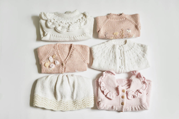 Stack of knitted clothes. Baby clothes. Needlework, hobby, knitting, handwork. - Fotoğraf, Görsel