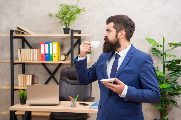 serious brutal ceo in businesslike suit hold morning coffee cup at the office, morning - Фото, зображення