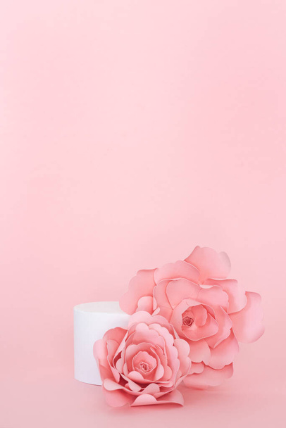 Blank circular platform for product presentation with paper roses on pink background. Copy space. - Фото, изображение