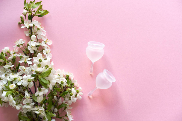 Copa menstrual de silicona. Salud de las mujeres e higiene alternativa. Copa con flores de primavera - Foto, Imagen