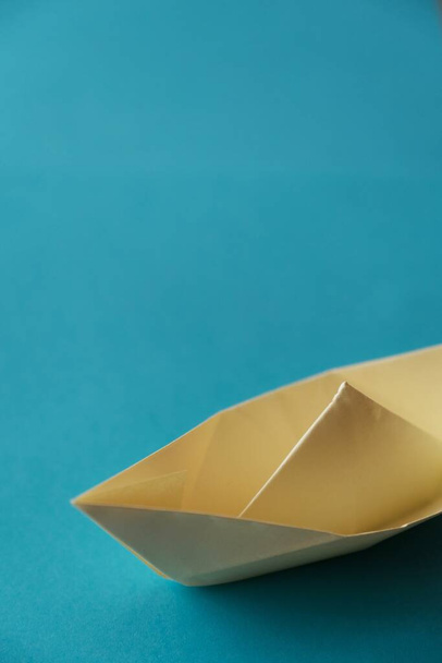 yellow origami paper boat on a blue background - Zdjęcie, obraz