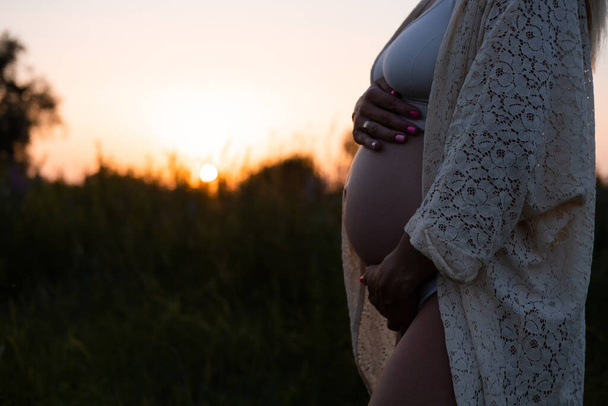 primer plano de lindo vientre embarazada en el fondo de la naturaleza. concepto de maternidad - Foto, imagen