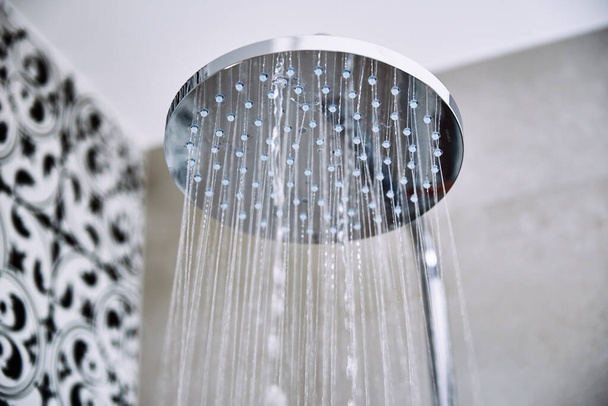 Water stroomt uit douchekop in badkamer - Foto, afbeelding