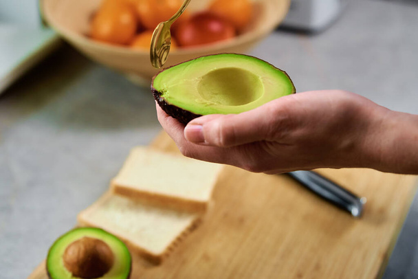 Ripe avocado in woman hands, Healthy breakfast - Φωτογραφία, εικόνα