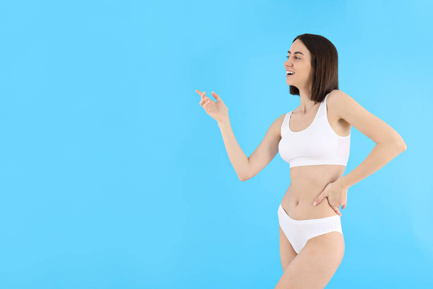 Concept of weight loss, young woman on blue background - Foto, Imagem
