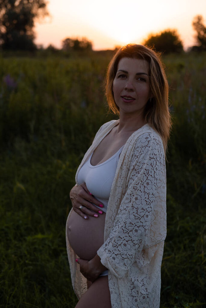 Outdoor pregnancy portrait: beautiful young pregnant female anticipate child, enjoy nature. Happy future mother expecting a baby soon. - Foto, Imagem