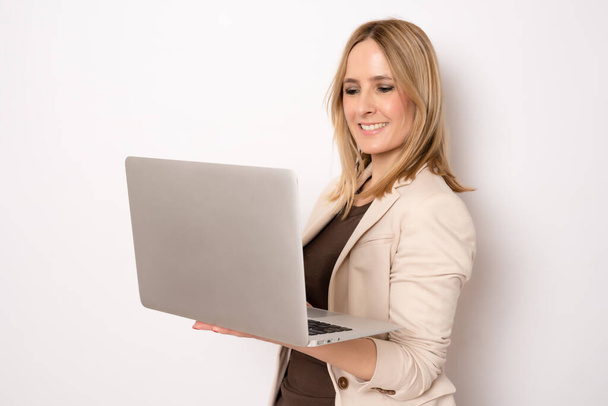 Jeune femme d'affaires avec ordinateur portable debout isolé sur fond blanc. - Photo, image